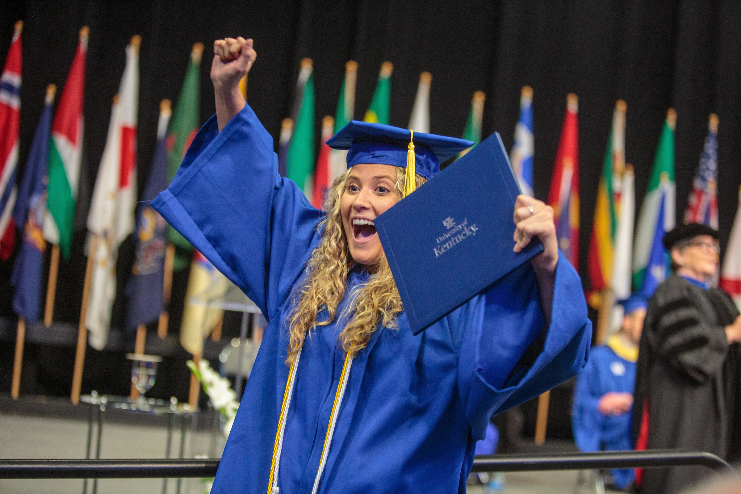 A graduate celebrates with their diploma